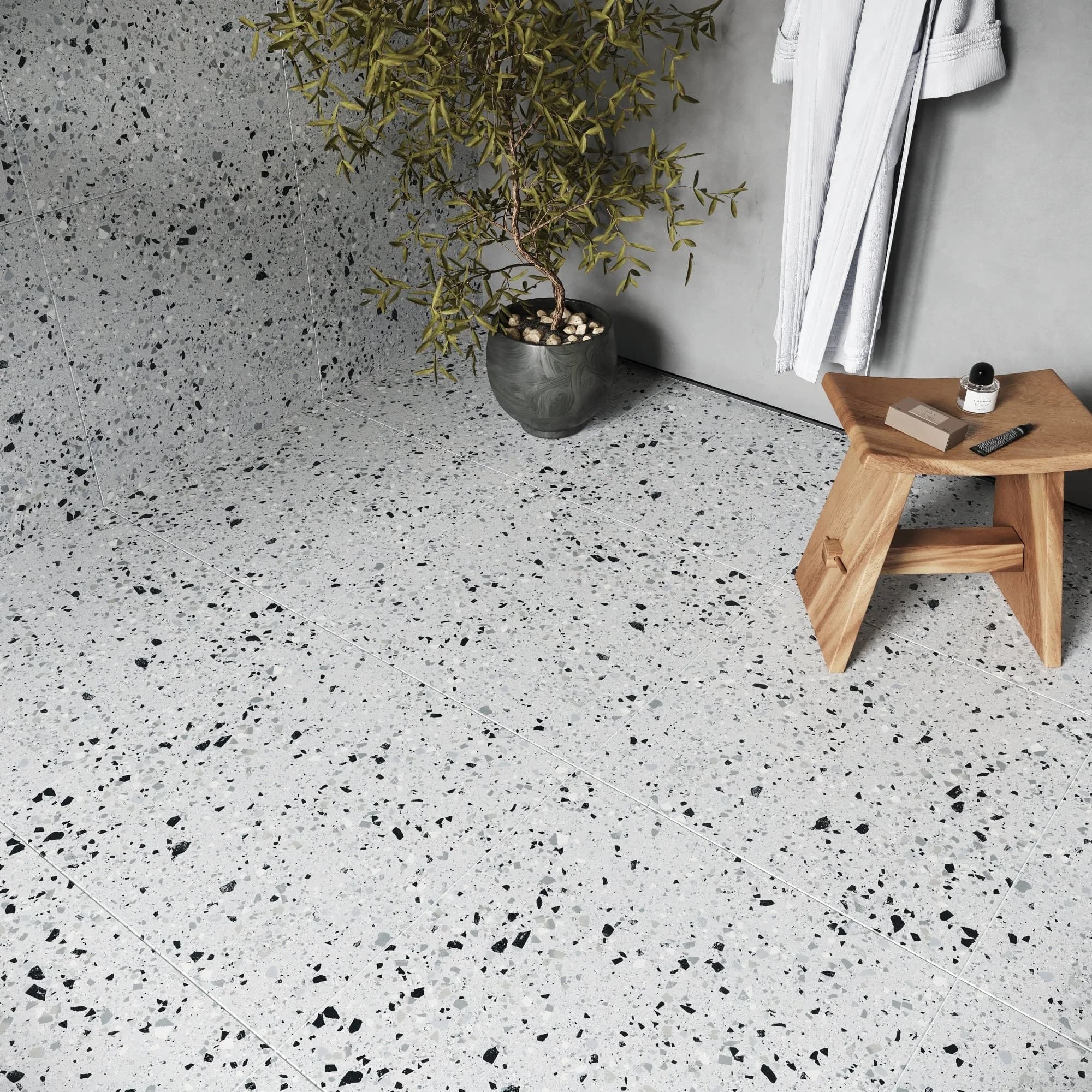 Modern terrazzo flooring in Riyadh interior with wooden stool and plant