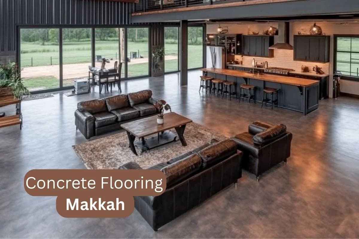 Polished concrete flooring in a spacious modern living room with open kitchen and large glass windows in Makkah, Saudi Arabia